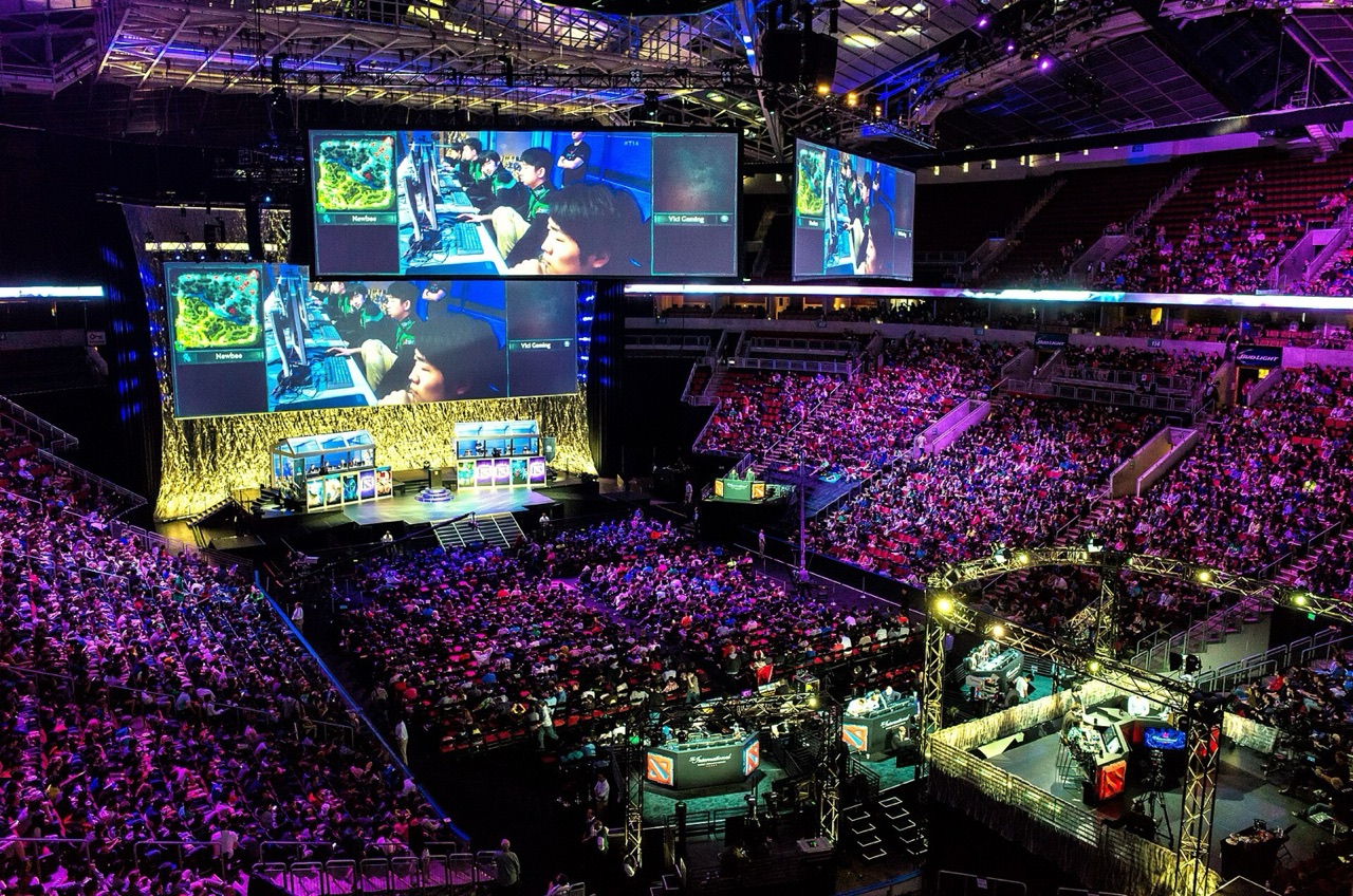 Packed KeyArena during Dota 2 The International with the competition stage and screens visible