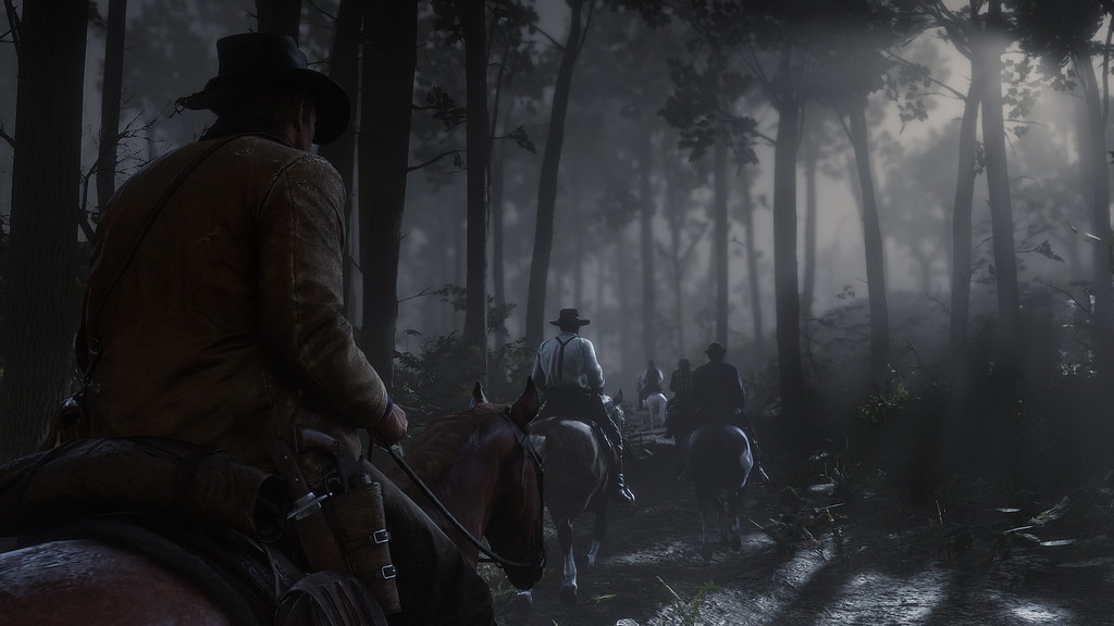 Arthur follows riders through a wooded trail on horseback